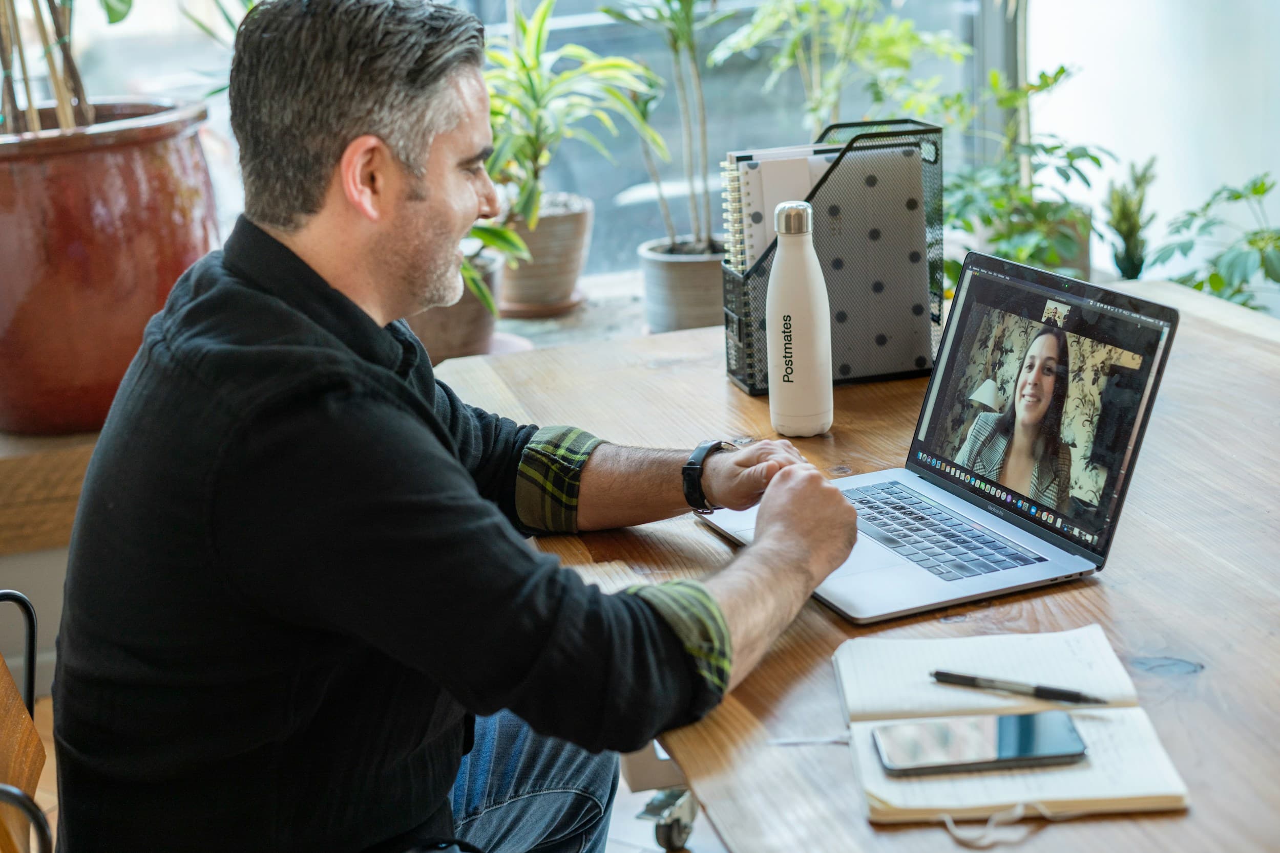 A man in a video meeting on his laptop at home